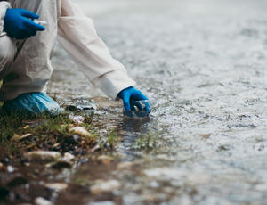 Scientist in protective suite taking water samples from the river / Photo © hedgehog94/Adobe Stock